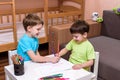 Two little caucasian friends playing with lots of colorful plastic blocks indoor. Active kid boys, siblings having fun building an Royalty Free Stock Photo