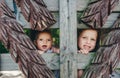 Two little children are behind the wooden fence, smiling and laughing Royalty Free Stock Photo