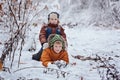 Two little children, boy brothers playing and lying in snow outdoors during snowfall. Active leisure with children in winter on co Royalty Free Stock Photo