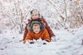 Two little children, boy brothers playing and lying in snow outdoors during snowfall. Active leisure with children in winter on c Royalty Free Stock Photo