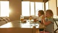 Two little children drinking orange juice, eating toasted bread with chocolate butter for breakfast or lunch while Royalty Free Stock Photo