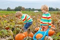 Two Little Children Enjoying Harvest Festival Celebration at Pumpkin Patch. Kids Preschool Boys Picking and Carving Royalty Free Stock Photo