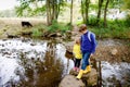 Two little children hiking in forest. Kid boy and toddler girl passing creek. Happy healthy kids having fun in nature Royalty Free Stock Photo