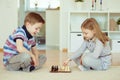 Two little children playing chess at home Royalty Free Stock Photo