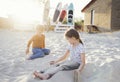 Two little cute children in casual clothes are playing on beach against backdrop of surfboards Royalty Free Stock Photo