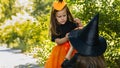 Two little cute girl in witch costume holding jack-o-lantern pumpkin bucket. Kids trick or treating in Halloween holiday Royalty Free Stock Photo