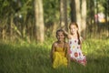 Two little cute girls posing in a pine forest. Game. Royalty Free Stock Photo