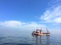 Two little fishing boats moored in the middle of blue turquoise ocean on sunny clear sky day Royalty Free Stock Photo