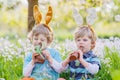 Two little friends with Easter bunny ears and eating chocolate Royalty Free Stock Photo