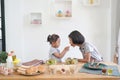 Two little girl eating salad and cooks in the kitchen Royalty Free Stock Photo