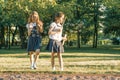 Two little girl friends schoolgirl 7, 8 years old play with soap bubbles on the meadow in the park Royalty Free Stock Photo