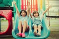 Two little girl have fun playing slider in the playground in par Royalty Free Stock Photo