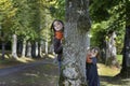 Two little girl looking from behind a tree