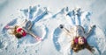 Two little girl making snow angel while lying on snow. Happy children girls on a snow angel shows. Royalty Free Stock Photo