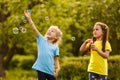 Two little girls are blowing soap bubbles, outdoor shoot. Royalty Free Stock Photo