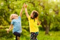 Two little girls are blowing soap bubbles, outdoor shoot. Royalty Free Stock Photo