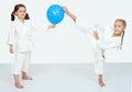 Two little girls with blue ball beat a karate kick leg