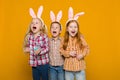 Two little girls and boy with Easter bunny ears holding colorful eggs Royalty Free Stock Photo