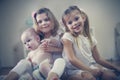 Two little girls care a baby brother. Royalty Free Stock Photo