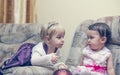 Two little girls chattingl on a sofa Royalty Free Stock Photo