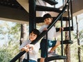 Two little girls climbed the stairs to the tower in the playground. Family outdoor recreational activity