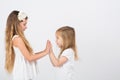 Two little girls dressed in white playing
