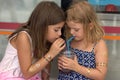 Two little girls, drinking from the same cup with two straws