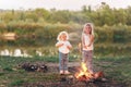 Two little girls is eating marshmallows. The children bakes sweetness at the stake Royalty Free Stock Photo