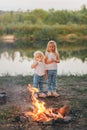 Two little girls is eating marshmallows. The children bakes sweetness at the stake. Vertical view Royalty Free Stock Photo