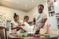 Two little girls feeling excited while cooking with their father