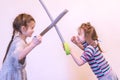 Two little girls are fighting on swords. toned Royalty Free Stock Photo