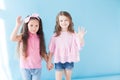 Two little girls girlfriends together on blue background