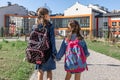 Two little girls go to school, holding hands, back view Royalty Free Stock Photo