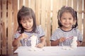 Two little girls having fun to paint on stucco doll Royalty Free Stock Photo