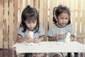 Two little girls having fun to paint on stucco doll Royalty Free Stock Photo