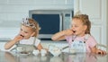 Two little girls having a princess tea party at home. Sibling sister friends wearing tiaras while playing with tea set