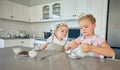 Two little girls having a tea party at home. Sibling sister friends wearing tiaras while playing with tea set and having Royalty Free Stock Photo