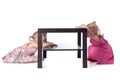 Two little girls hiding behind table Royalty Free Stock Photo