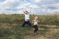 Two little girls jump on the field Royalty Free Stock Photo