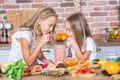 Two little girls in the kitchen with fresh vegetables. Healthy food concept. Royalty Free Stock Photo