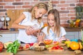 Two little girls in the kitchen with fresh vegetables. Healthy food concept. Royalty Free Stock Photo