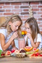 Two little girls in the kitchen with fresh vegetables. Healthy food concept. Happy sisters. Royalty Free Stock Photo