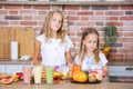 Two little girls in the kitchen with fresh vegetables. Healthy food concept. Happy sisters. Royalty Free Stock Photo