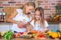 Two little girls in the kitchen with fresh vegetables. Healthy food concept. Royalty Free Stock Photo