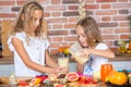 Two little girls in the kitchen with fresh vegetables. Healthy food concept. Royalty Free Stock Photo