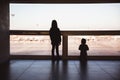 Two little girls are looking to airplans in airport waiting lounge in Budapest Royalty Free Stock Photo