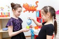 Two little girls play role game with toy kitchen in day care center