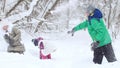 Two little girls playing with their friend in the snow in winter forest. Throwing snowballs Royalty Free Stock Photo
