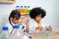 Two little girls practice in science class with different laboratory equipment with concentrate in their work