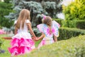 Two little girls, princess and fairy, walk hands in the garden Royalty Free Stock Photo